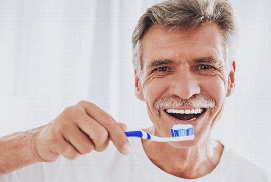 elderly man brushing teeth