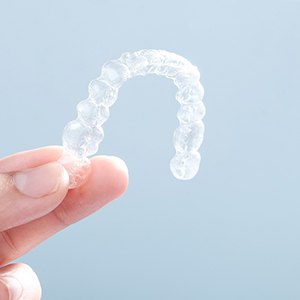 Patient holding up clear aligners