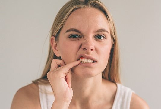Woman pointing to damaged gum tissue