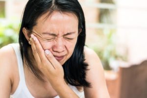 woman in pain who needs emergency dentist 