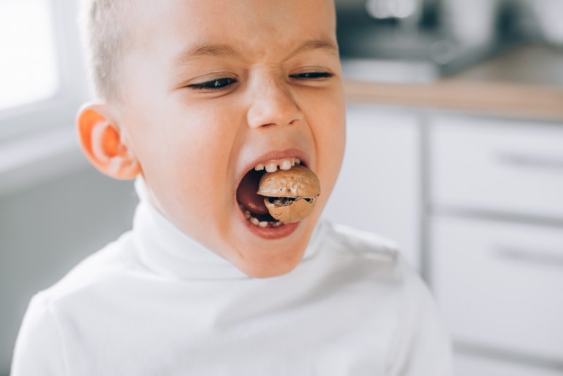 little boy in Raleigh biting hard food that can chip teeth