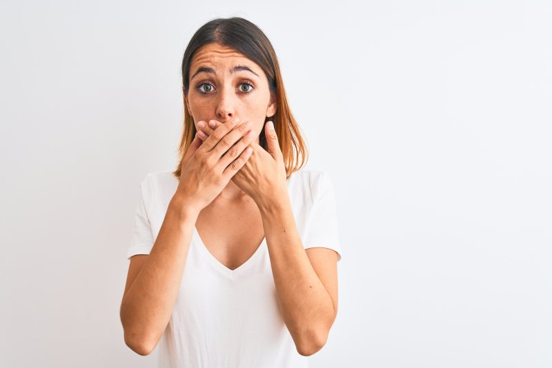 a woman covering her mouth due to lost dental filling